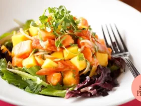 Salada de folhas com frutas tropicais e nozes caramelizadas